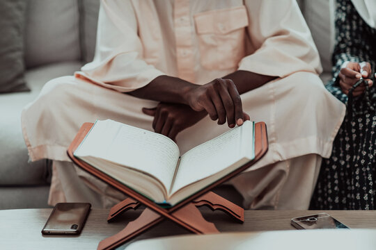 African Muslim couple at home in Ramadan reading Quran holly Islam book.
