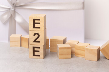 e2e - letters on wooden cubes. concept on white gift box background