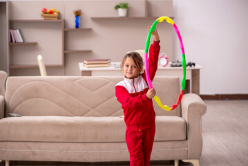 Young little girl doing sport exercises at home