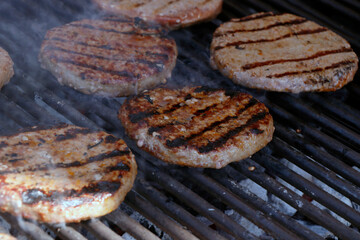 beef meat burger patty on a hot smoky barbeque grill