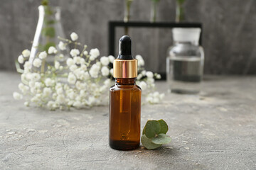 Bottle of natural eucalyptus essential oil on grunge background