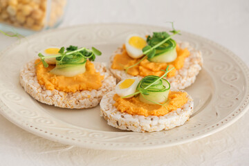 Plate with crispbreads and tasty hummus on white background