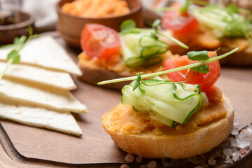 Board with piece of bread and tasty hummus, closeup
