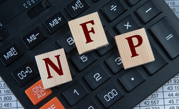 NFP - acronym on wooden cubes on the background of a calculator