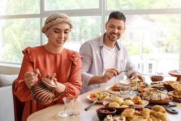 Muslim couple having breakfast together. Celebration of Eid al-Fitr