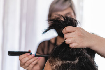 Fototapeta premium Unknown woman giving her client a haircut 