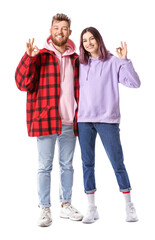 Obraz premium Cool young couple in hoodies showing OK on white background
