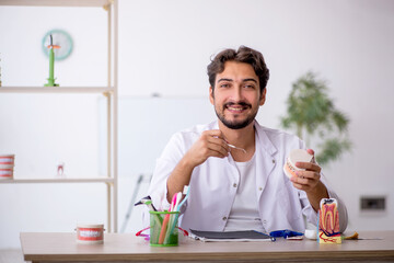 Young male dentist working in the clinic