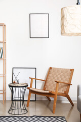 Interior of light living room with wooden armchair and blank frames