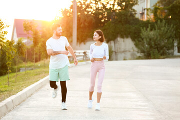 Young couple in sportswear running outdoors