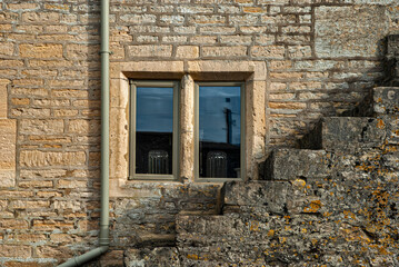 Fototapeta na wymiar Window of old country house wall with stone staircase