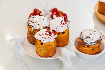 decorated panettones and cruffins on serving plates with rabbits. easter cakes. 