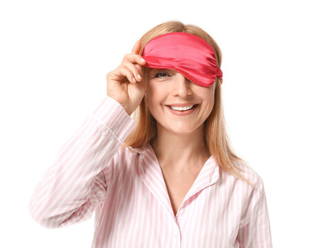 Happy mature woman in pajamas and with sleeping mask on white background