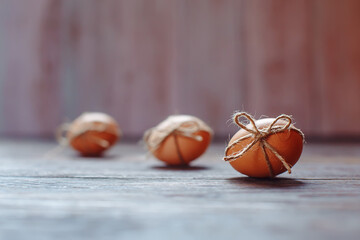 Easter beige eggs decorate with rope on brown wooden background