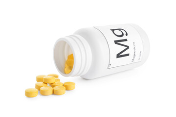 Overturned bottle of magnesium pills on white background