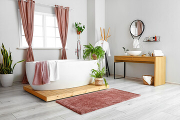 Interior of stylish bathroom with beautiful houseplants