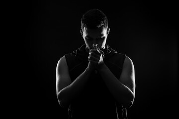 Silhouette of sporty young man on dark background, black and white effect