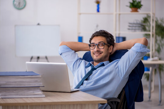Young businessman employee and too much work in the office