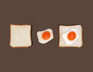 Creative pattern of lined eggs and bread on a brown background. Retro trendy aesthetic food concept from the 80s or 90s. Minimal idea for breakfast.