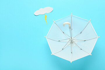 Composition with umbrella, paper cloud and lightning on color background