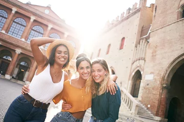 Küchenrückwand glas motiv Three happy female friends having fun outdoors in summer vacations at city. Portrait of smiling woman hugging looking at camera together © CarlosBarquero