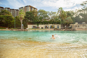 Kids swimming at the Settlement Cove Lagoon swimming pool in Redcliffe, QLD Australia - obrazy, fototapety, plakaty