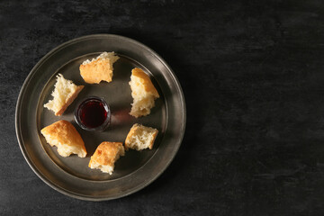 Tray with glass of wine and bread on dark background
