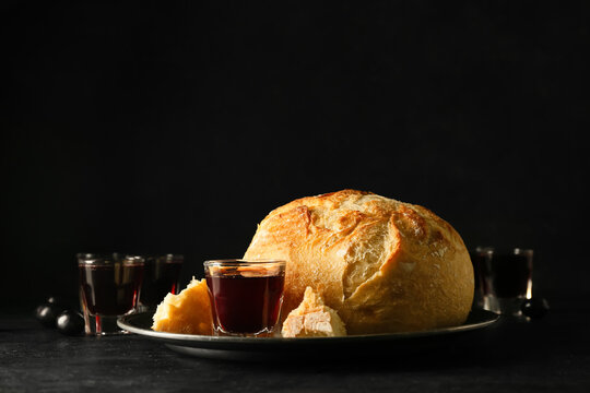 Tray with glass of wine and bread on dark background