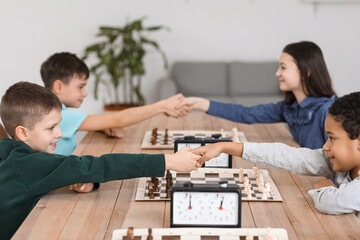 Little children shaking hands before chess tournament in club