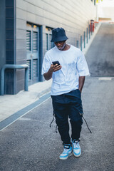 Black man posing with a mobile phone in the streets