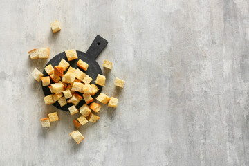 Board with crunchy croutons on table