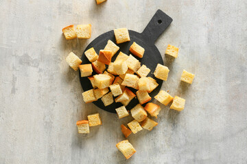 Board with crunchy croutons on table, top view