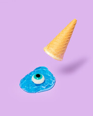 Creative look of an ice cream cone with an eye and an egg, on a purple background. Surreal fashion and trendy concept of the 80s, 90s. Minimal idea summer and refreshment.