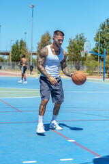 Sporty Caucasian male with tattoos playing basketball