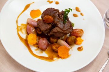 Traditional Italian baked beef fillet marinated with rosemary served in sauce with shallots, sweet potatoes slices and chestnuts