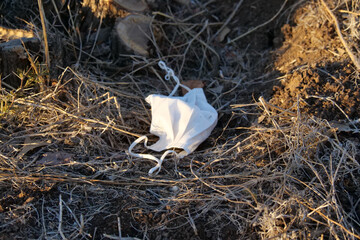 Face mask discarded in nature, a new problem or form of pollution, rubbish or trash in nature