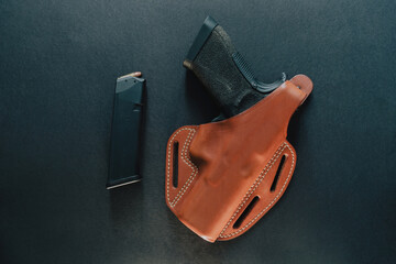Isolated shot of a gun covered with leather holster on the table - Powered by Adobe