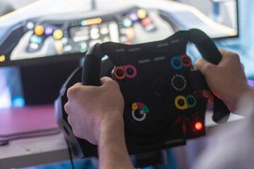 person improving his driving skills, race simulator with steering wheel and pedals