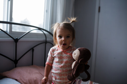 girl with stuffed animal on bed