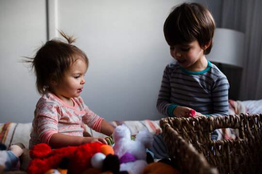 brother and sister play on bed