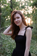 portrait of sensual young woman in a black dress in the forest. freedom, loneliness. nature loving