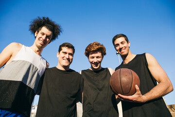 Young cheerful basketball players posing together 