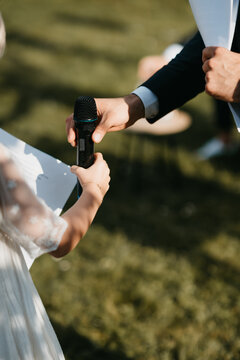 master of ceremonies handing down the microphone to kid