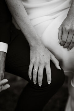 black and white image of bride holding knee of groom