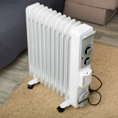 Electric oil-filled radiator heater for home on floor at room