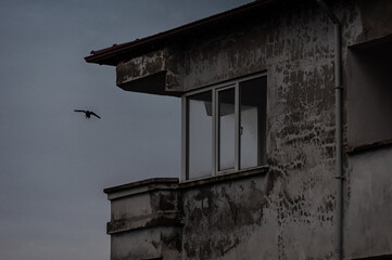 old desolated building with birds flying over during rain and thunderstorm 