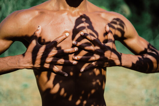 Portrait of expressive male dancer in nature with tree shadows 