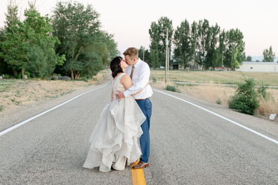 Bride and Groom Kissing in Middle of Street