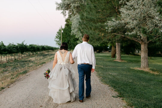 Couple Walking down Path at Sunset on Wedding Day