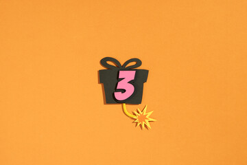 Number three with gift box on orange background - paper cut style